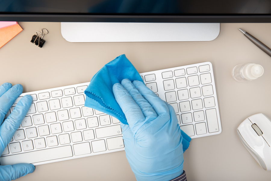 keyboard on desk in office being cleaned by Spotless cleaning operative.